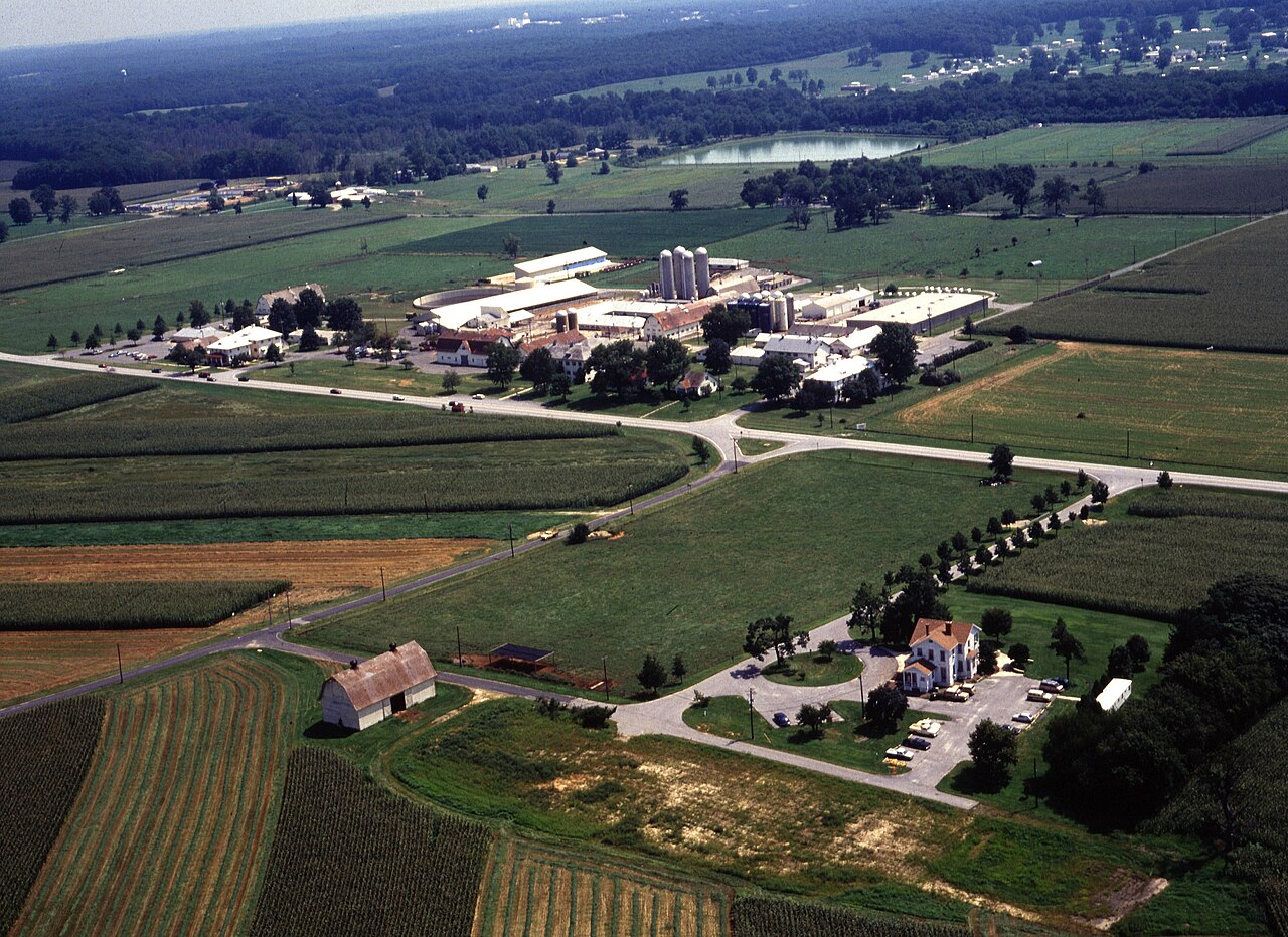 Aerial photograph of the Beltsville Agricultural Research Center grounds in Maryland, showing fields, farm buildings, and research facilities.